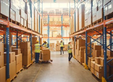 Retail Warehouse full of Shelves with Goods in Cardboard Boxes, Workers Scan and Sort Packages, Move Inventory with Pallet Trucks and Forklifts. Product Distribution Delivery Center.